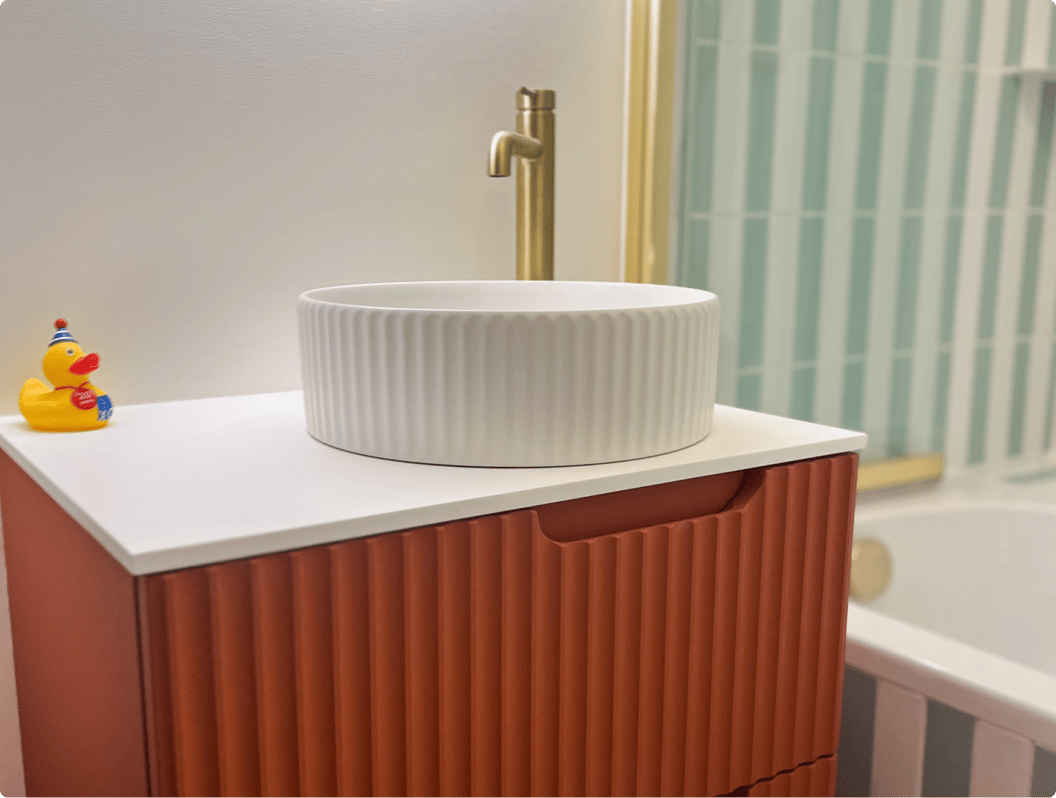 Detail van het X2O badkamermeubel in oranje ribbelstructuur met witte waskom, lade in geopende stand.