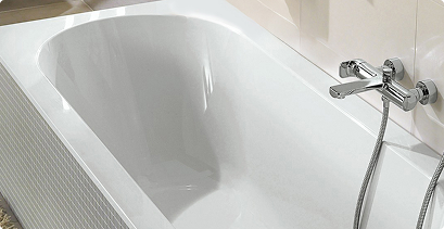 Glänzend weiße Badewanne in klassischer Form mit verchromter Wandarmatur und Handbrause.