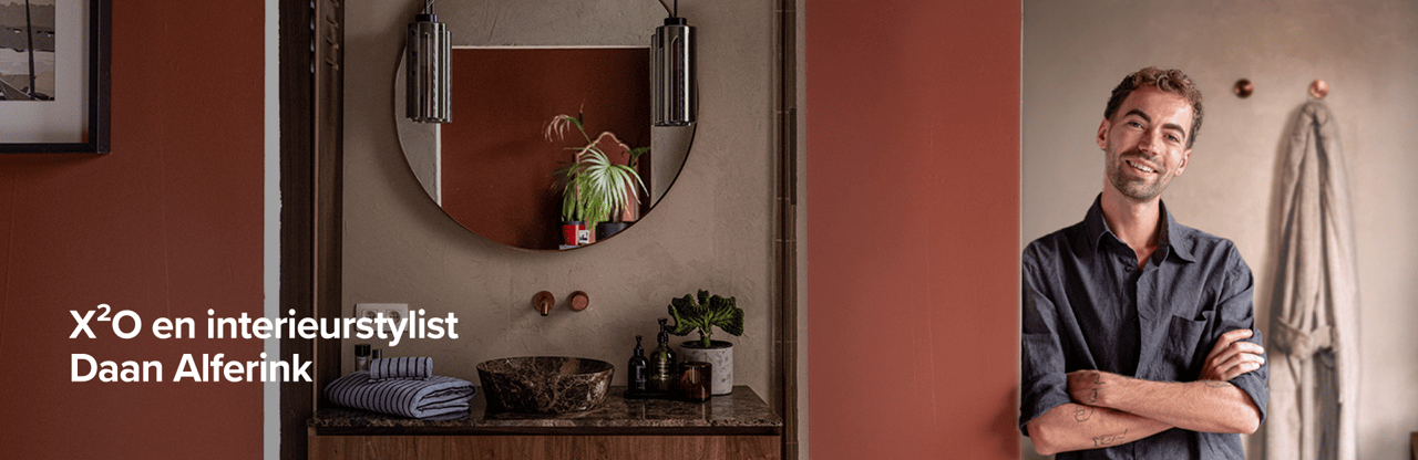 Interieurstylist Daan Alferink poseert trots in zijn stijlvolle badkamer met X²O meubelen.