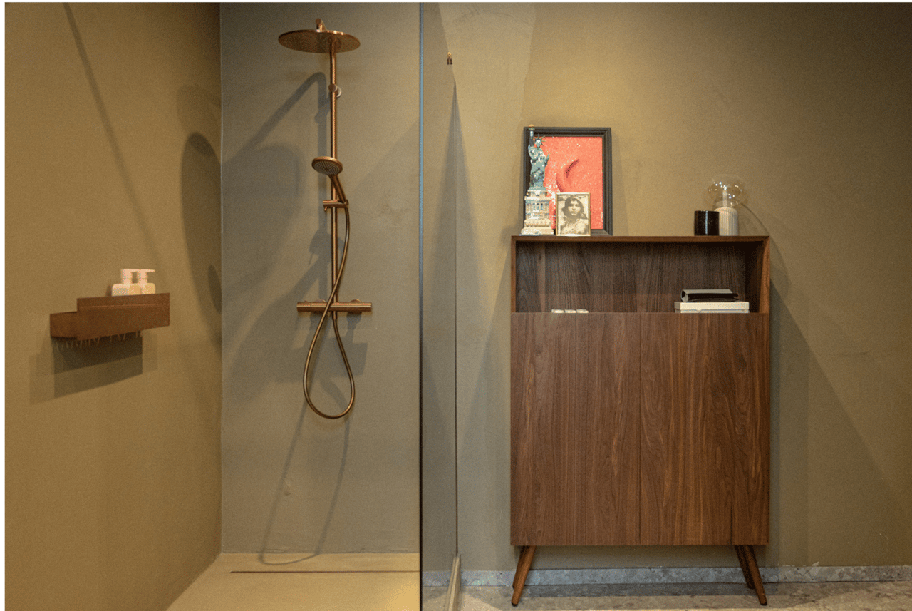 Inloopdouche met regendouche en houten kastje met persoonlijke decoratie.