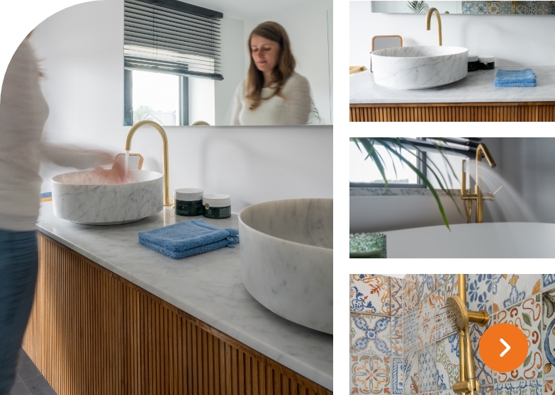 Badezimmer mit Marmorwaschbecken, Holzschrank und goldener Armatur sowie bunten Fliesen