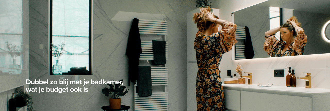 Vrouw maakt zich klaar voor de spiegel in een stijlvolle badkamer met witte marmeren muren, X2O badkamers.