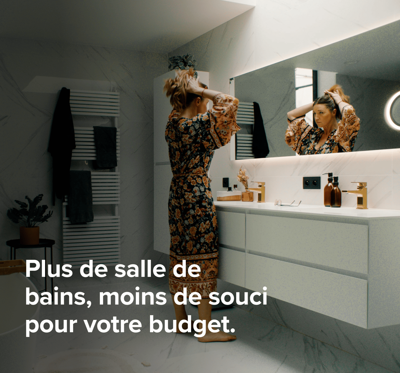 Femme devant le miroir dans une salle de bains élégante avec murs en marbre blanc, X2O salles de bains.