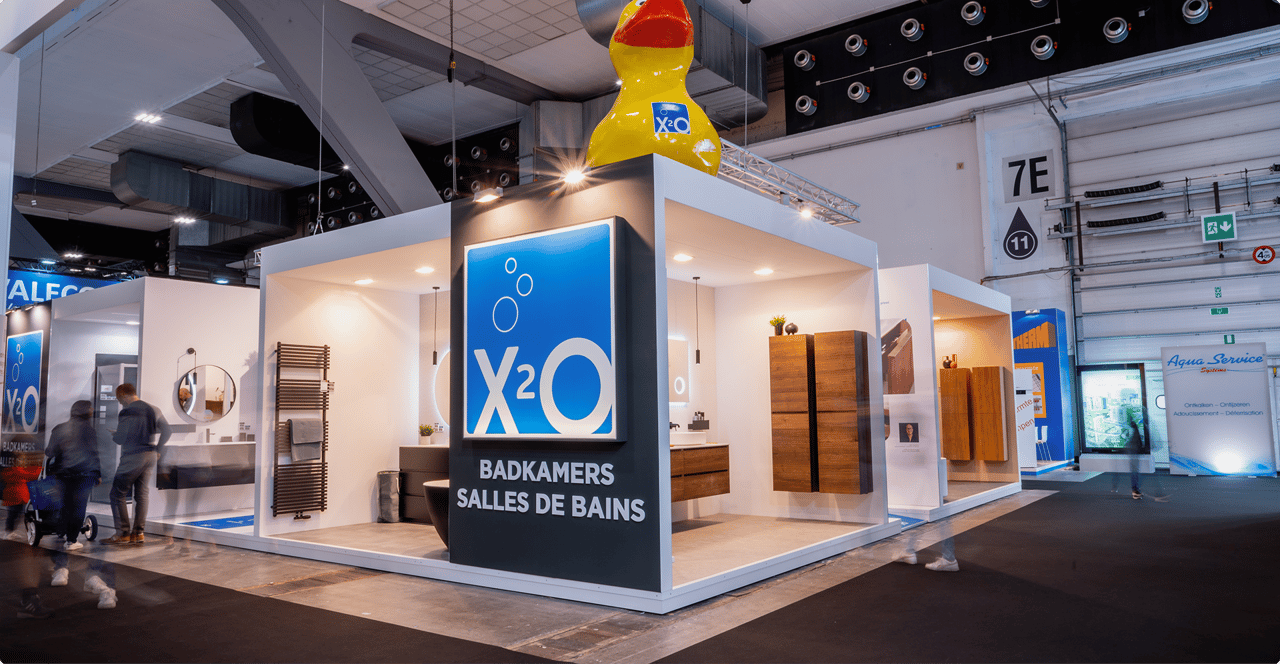 Vue d’ensemble du stand X²O au salon BIS, avec un logo bleu accrocheur et des meubles de salle de bains de différents styles.