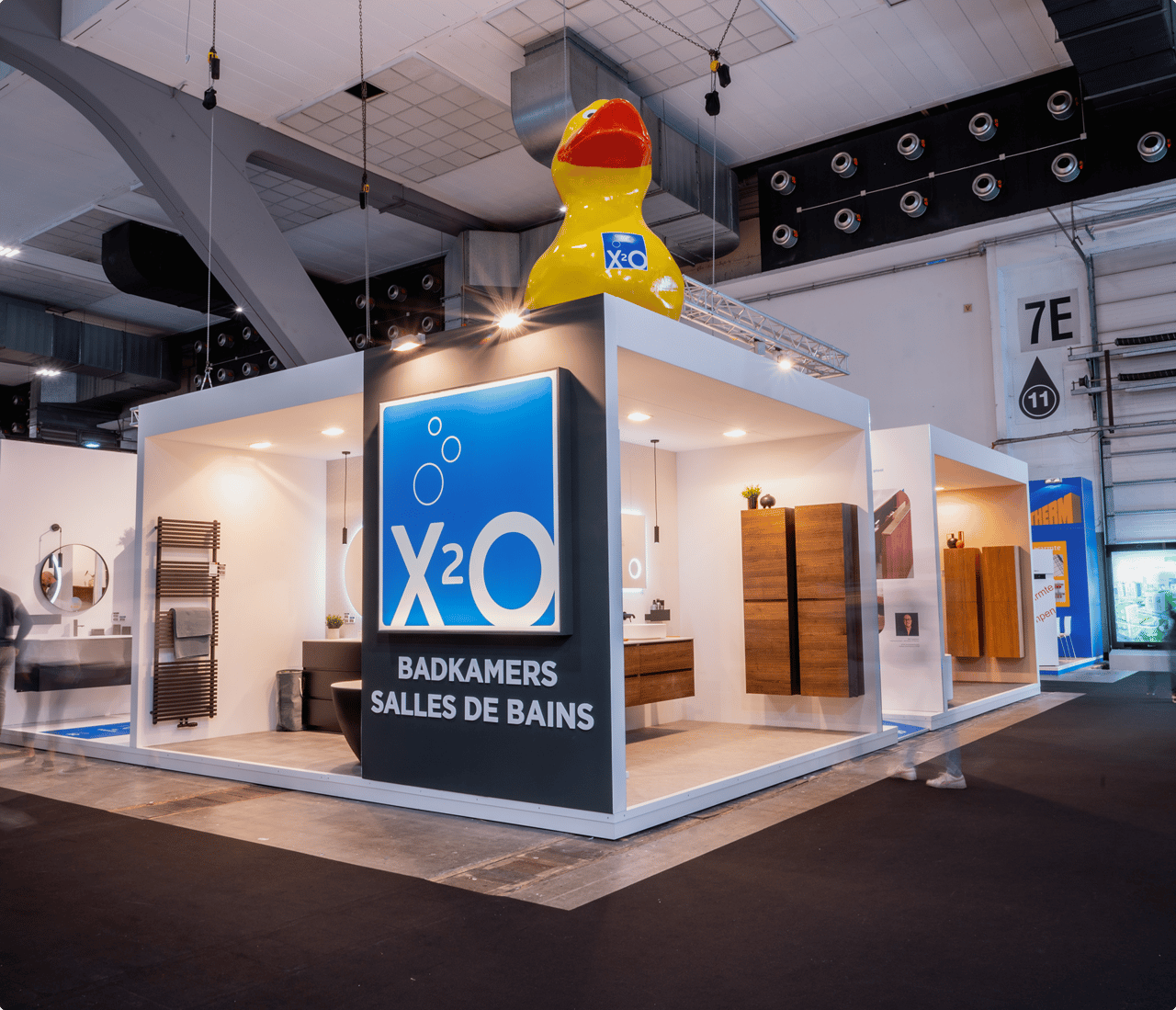 Vue d’ensemble du stand X²O au salon BIS, avec un logo bleu accrocheur et des meubles de salle de bains de différents styles.