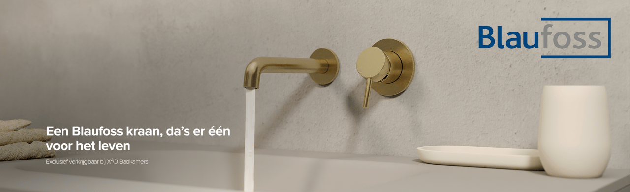 Gouden wandkraan van Blaufoss boven een wastafel met neutrale betonlook achterwand – exclusief verkrijgbaar bij X²O Badkamers.