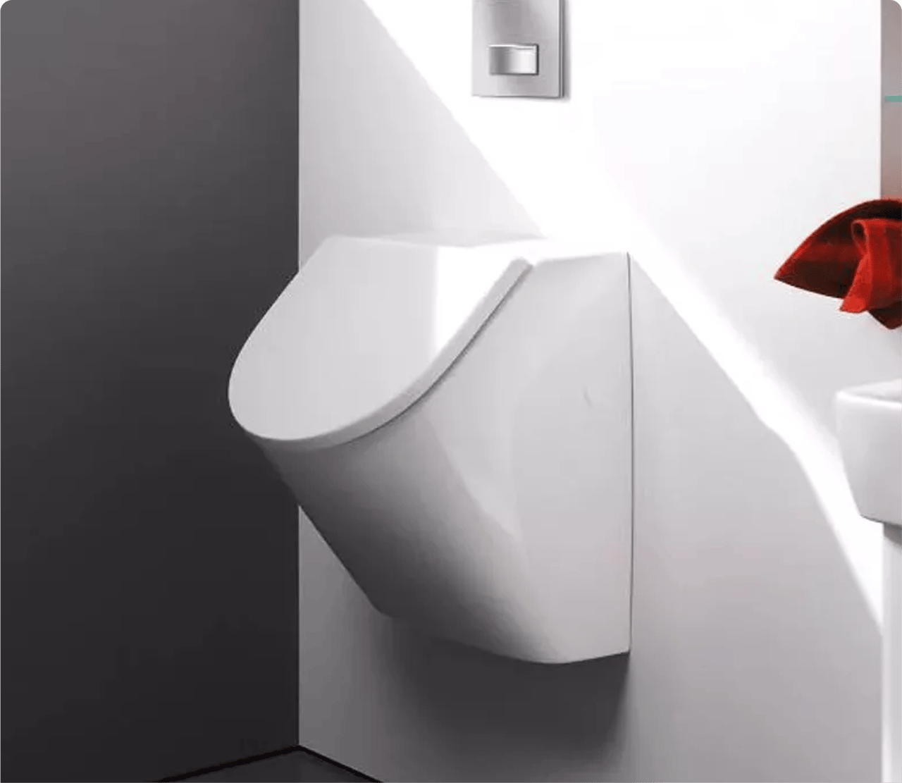 Een wit wandurinoir tussen twee contrasterende muren, met spoelknop erboven. Functioneel sanitair van x²o badkamers.