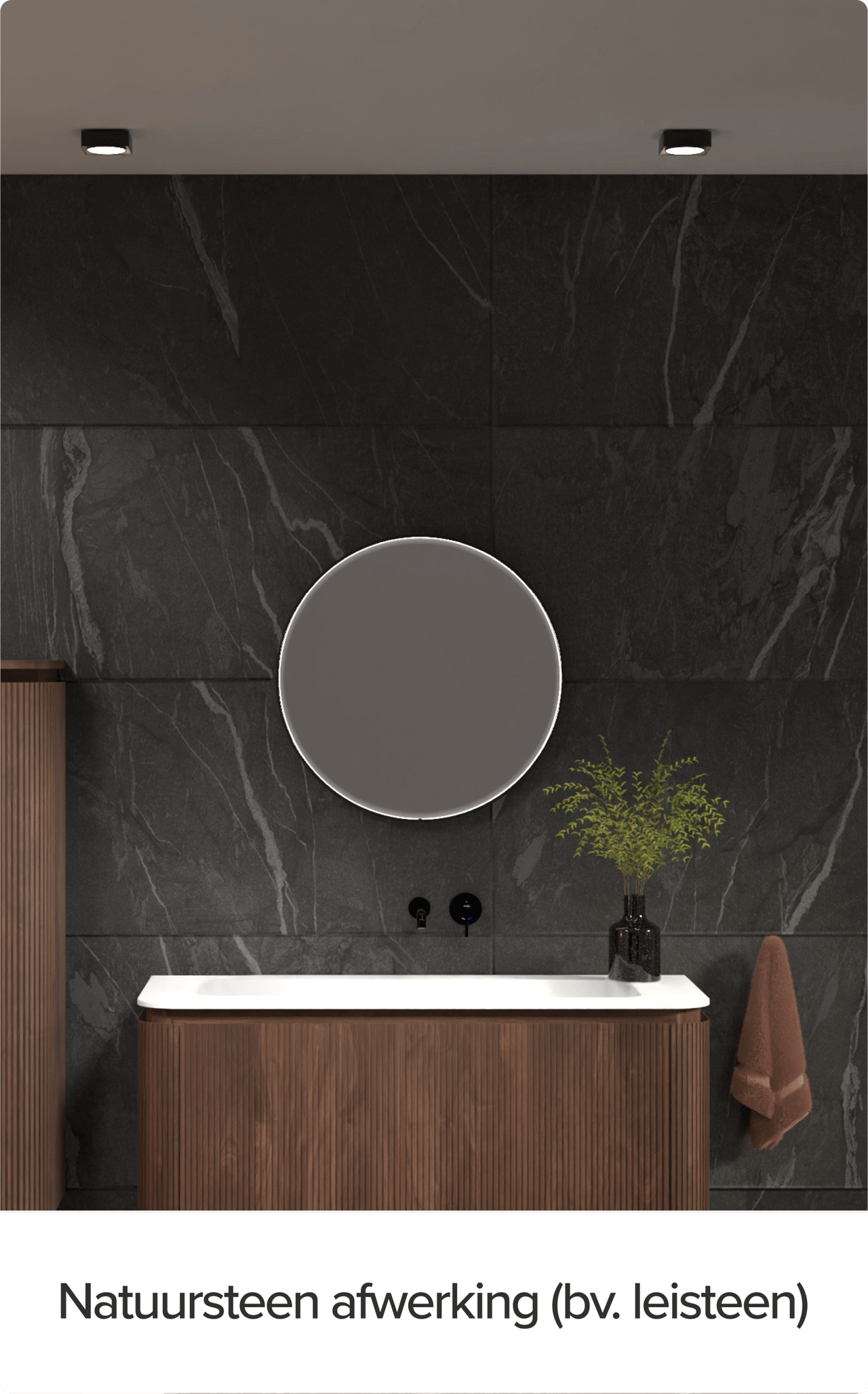 x²o badkamers meubel tegen een wand met natuursteenafwerking in leisteen-look. Rond verlicht spiegel, verticale houten kolomkasten en een zwart kraantje boven een wit werkblad benadrukken het luxe karakter.