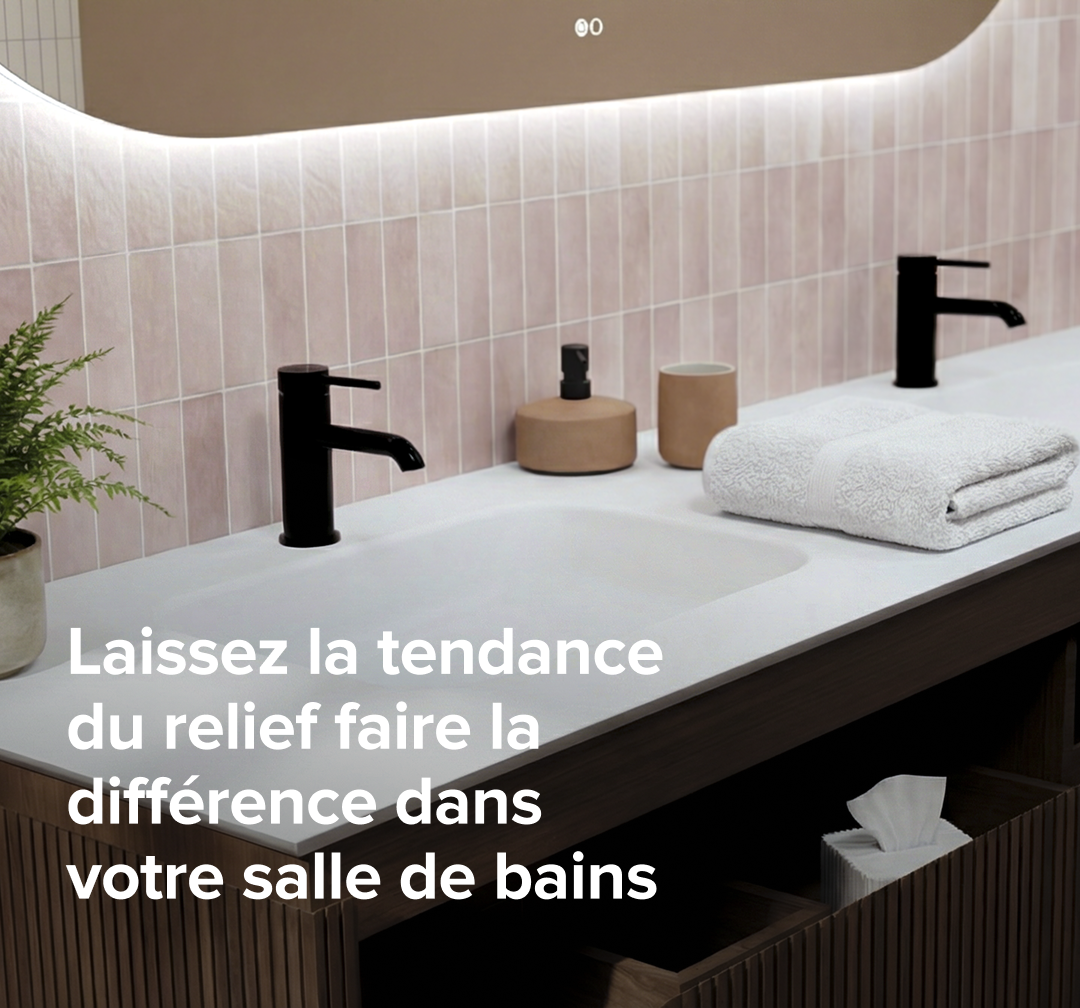 Meuble de salle de bains nervuré brun avec plan vasque blanc, robinets noirs et miroir avec éclairage intégré devant un mur de carreaux rose pastel.