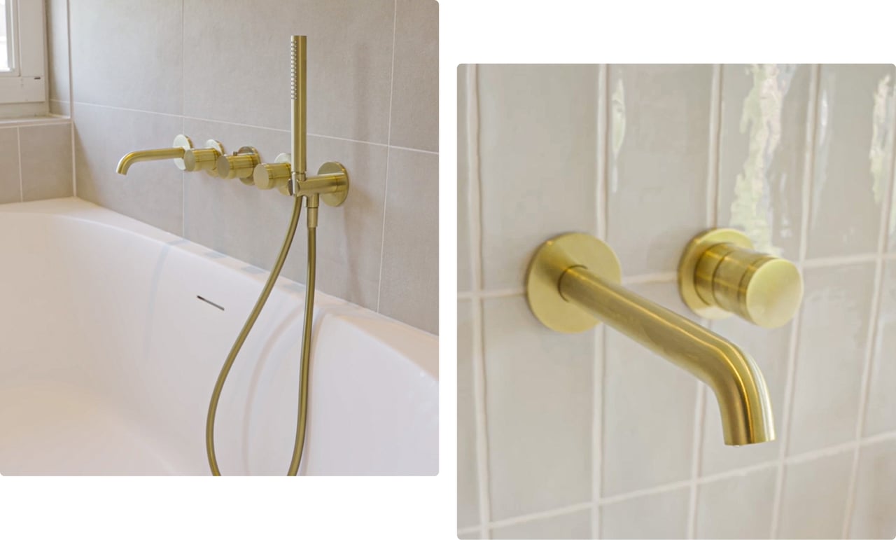 Goldene Wandarmatur und Handbrause über einer weißen Badewanne, angebracht an einer Wand mit matten, neutralen Fliesen. Design von x²o Bad.