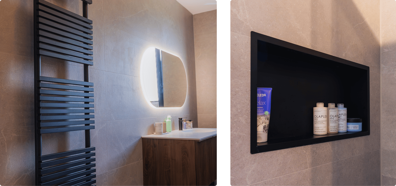 Links: Zwarte designradiator naast houten wastafel en ovale spiegel met verlichting. Rechts: Ingebouwde nis met verzorgingsproducten in zwarte omlijsting.