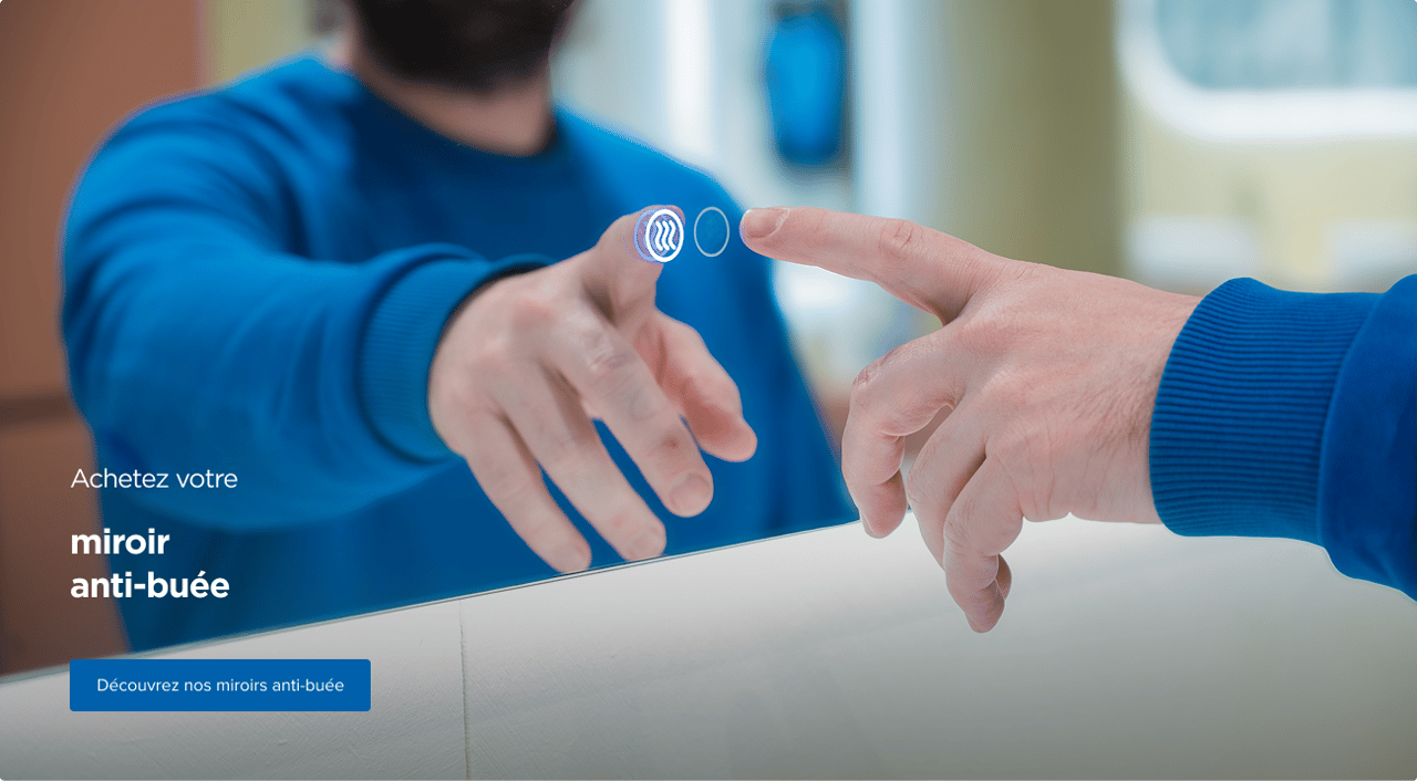 Un homme en pull bleu active la fonction anti-buée d’un miroir intelligent X²O en touchant une icône rétroéclairée sur la surface du miroir, illustrant la technologie avancée des miroirs de salle de bains X²O.
