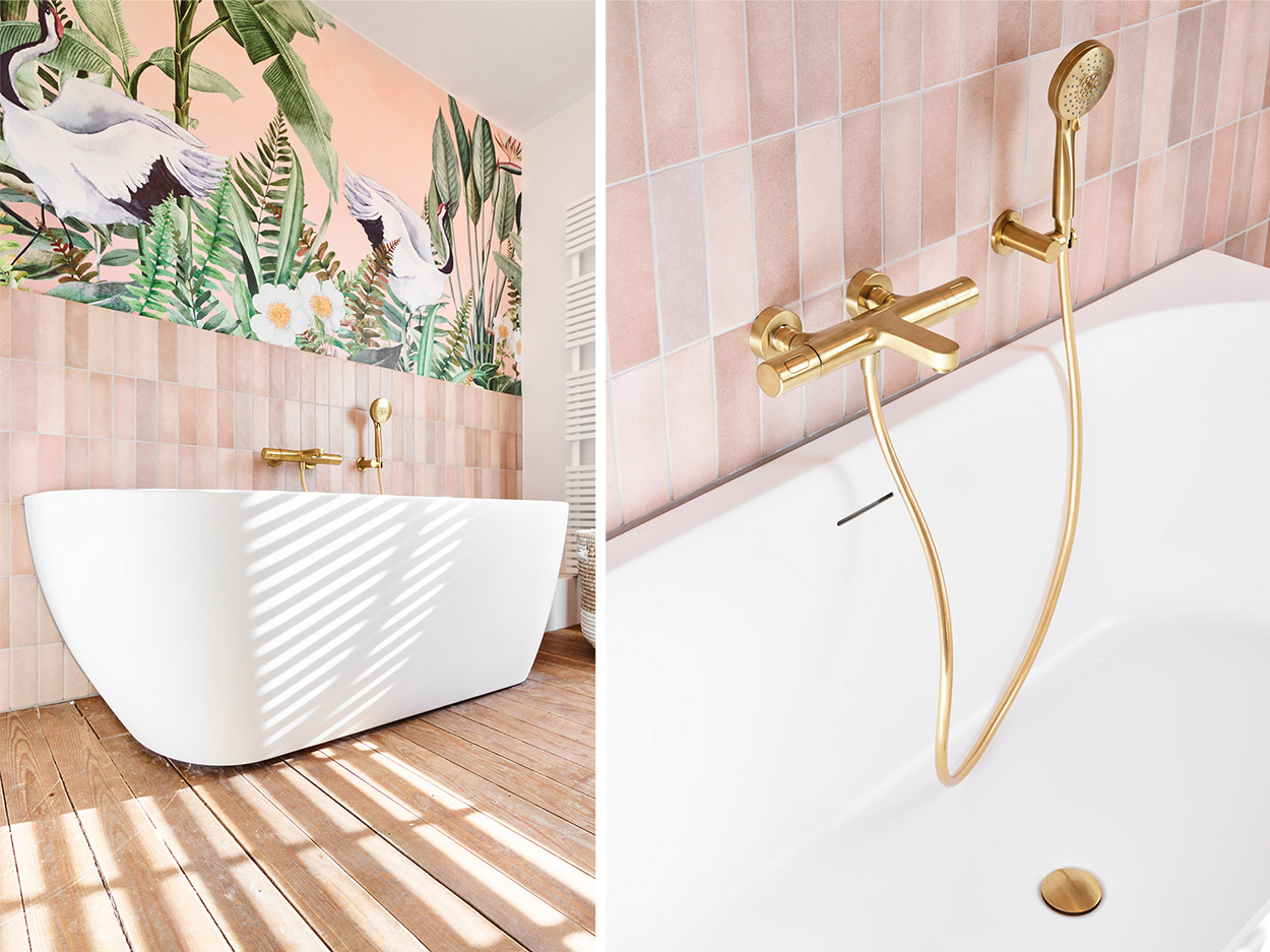 Goldene Badewannenarmatur und Wand mit tropischer Tapete