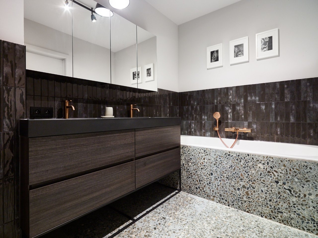 Stilvolles Badezimmer mit dunklen Fliesen und einem modernen Doppelwaschbecken