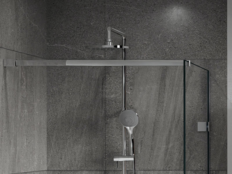  Detail van een moderne inloopdouche met glazen wand, regen- en handdouchekoppen.