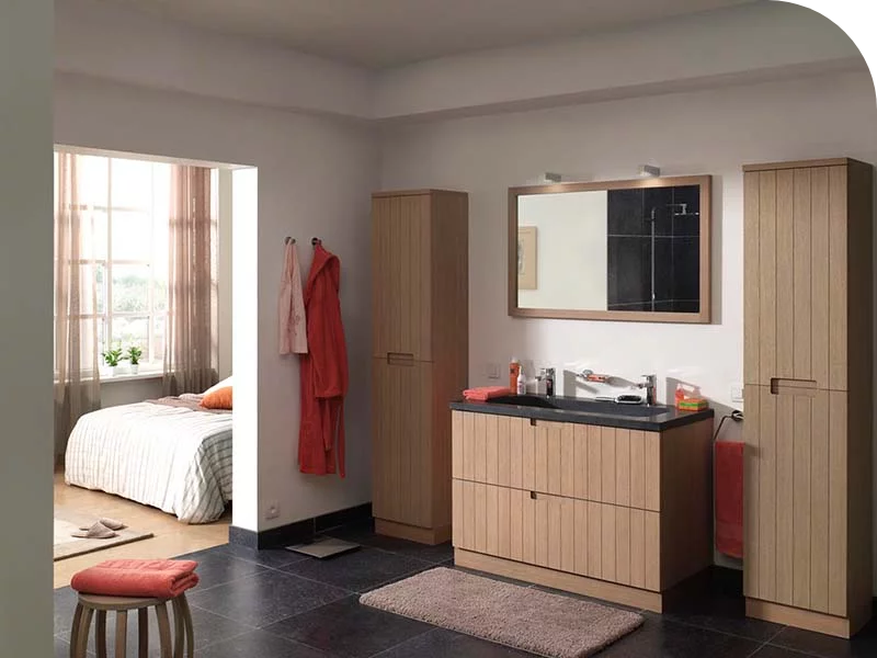  Badkamer met houten meubels, een donkere wastafel, grote spiegel en opgeruimde opbergkasten.