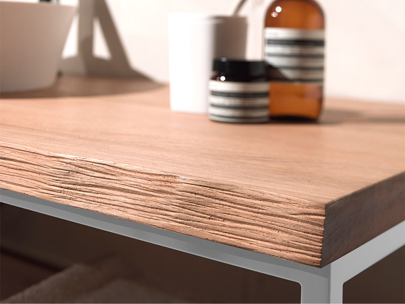 Close-up van een moderne houten badkamerplank met een minimalistisch ontwerp, inclusief decoratieve potjes en een witte beker.