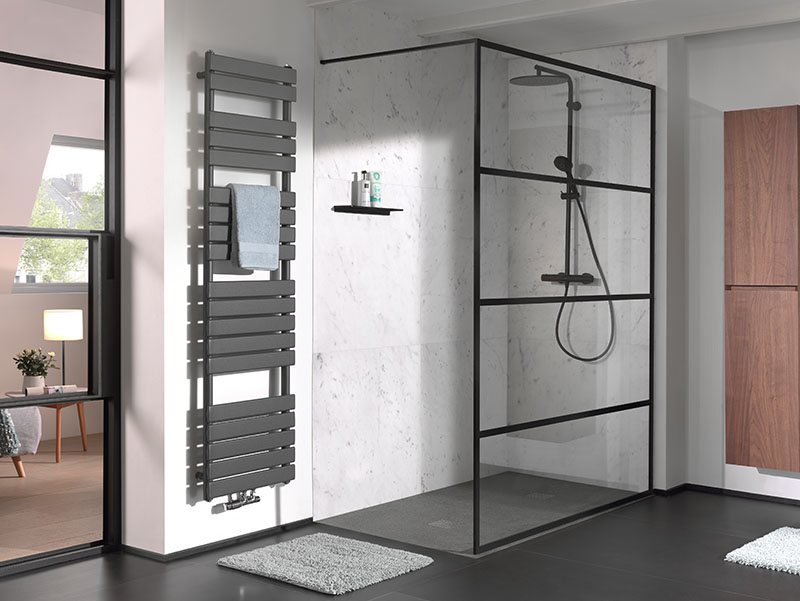 Inloopdouche met zwart frame en marmeren wand, gecombineerd met een modern handdoekradiator.