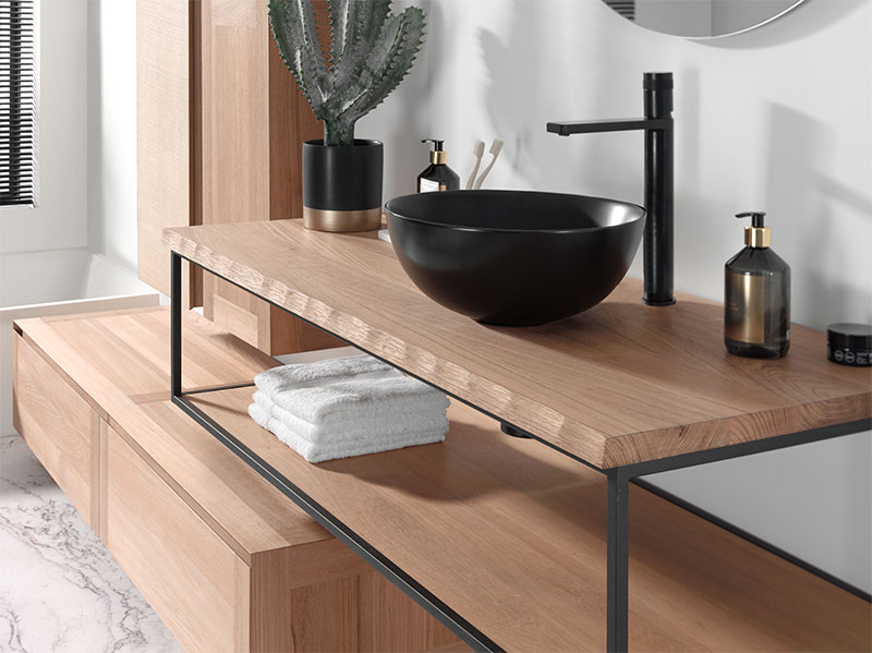 Houten badkamermeubel met zwart metalen frame, zwarte opzetwaskom en bijpassende kraan, modern design.