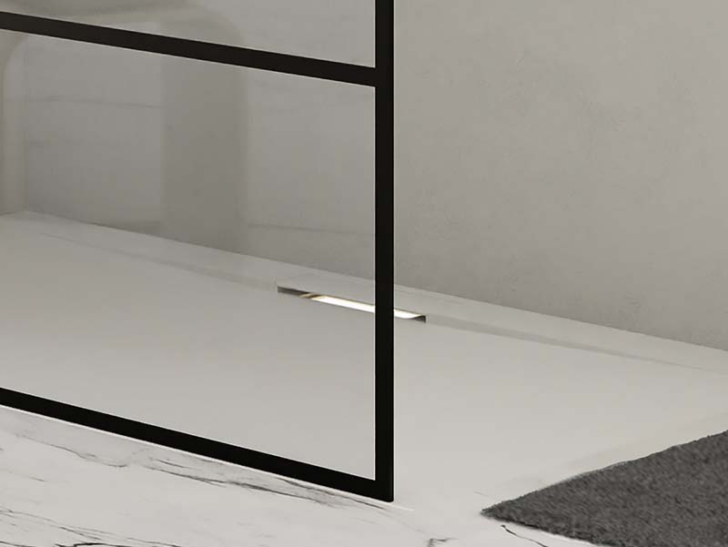 Minimalistische inloopdouche met zwart frame en discreet geïntegreerde afvoer in marmeren vloer.
