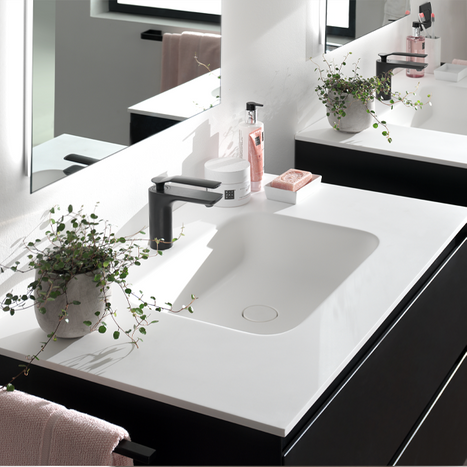 Stilvolles Waschbecken aus weißer Keramik mit schwarzem Badmöbel und mattschwarzer Armatur.