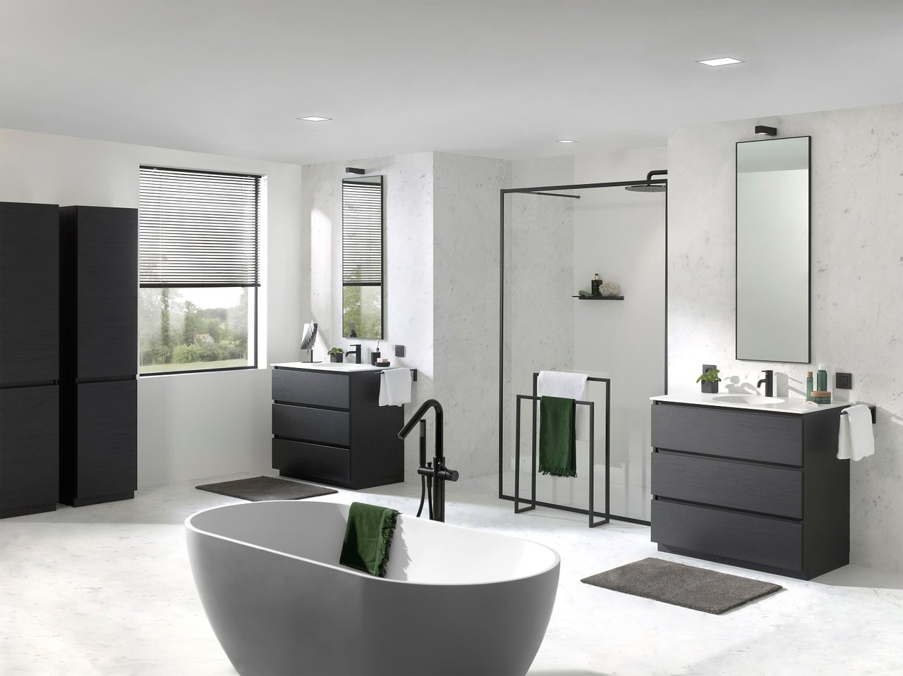 Grande salle de bains avec deux meubles vasques noirs, douche à l’italienne et baignoire îlot design.