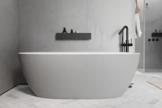 Salle de bains minimaliste avec baignoire îlot blanche, robinet noir et murs gris béton pour un design moderne.