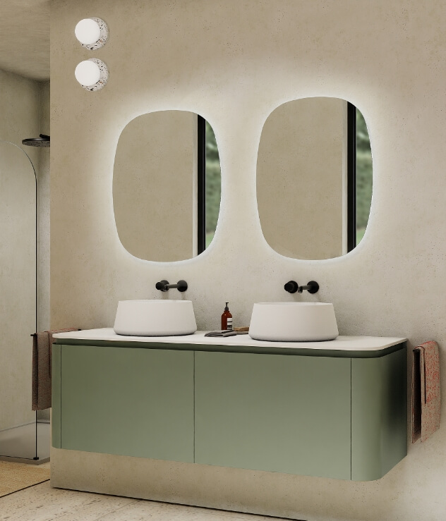 Meuble de salle de bain vert avec deux vasques, miroirs organiques et éclairage d’ambiance intégré.