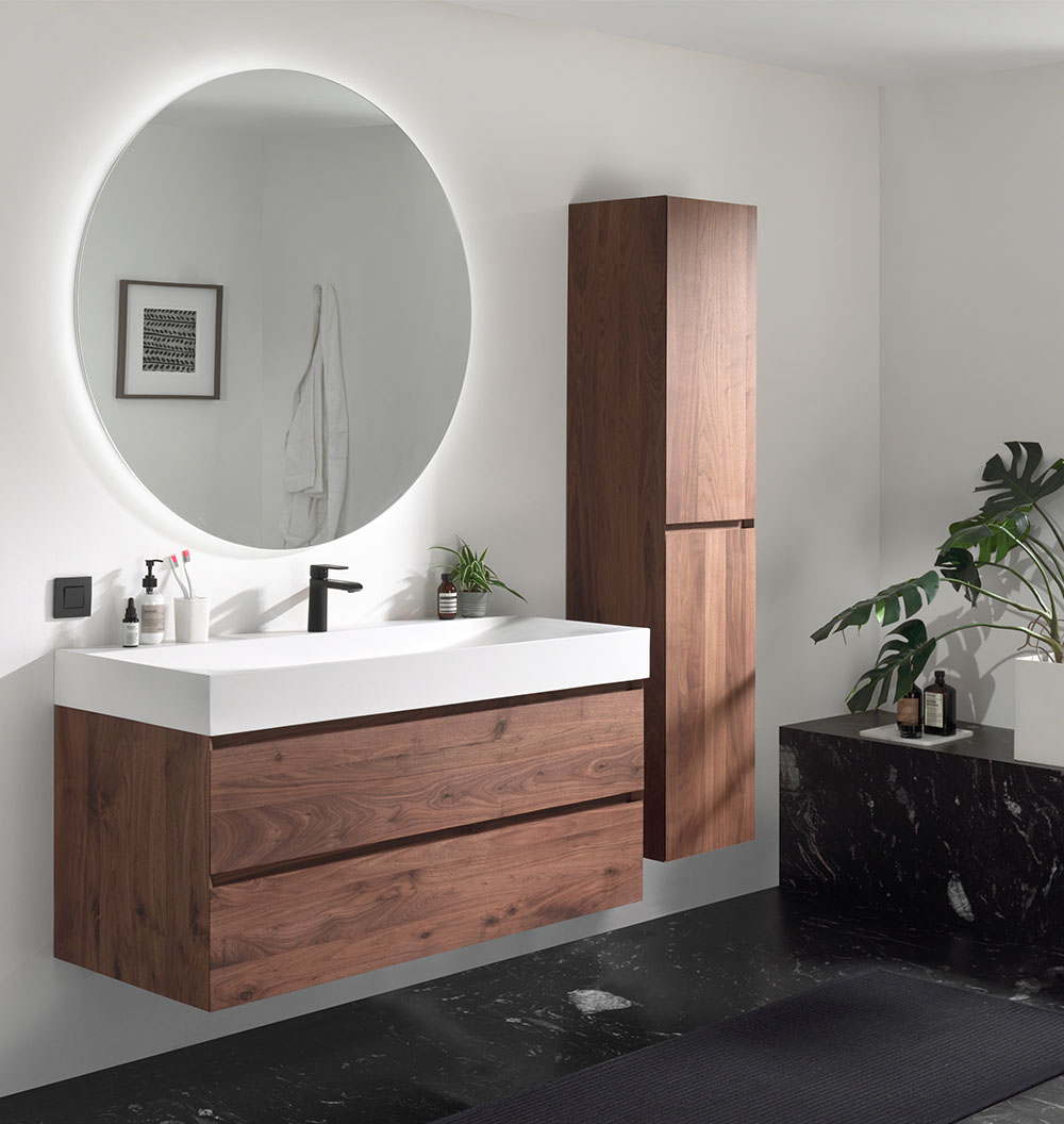 Moderne badkamer met houten wastafelmeubel, ronde spiegel, zwarte kranen en marmeren accenten.