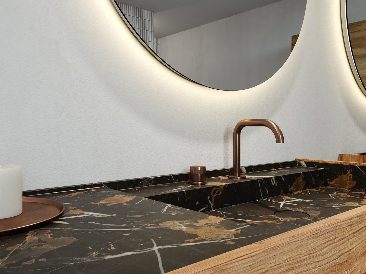 Zwart marmeren wastafelblad met gouden aderen en koperen kraan, ronde spiegel met verlichting.