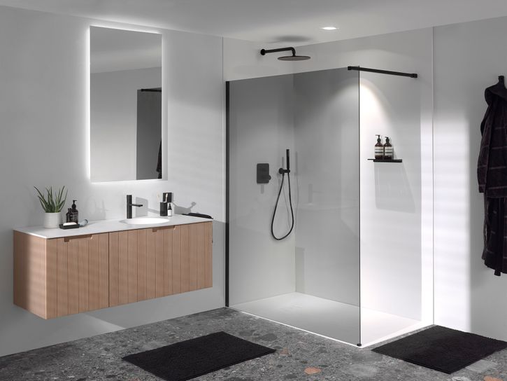 Salle de bains moderne avec meuble lavabo suspendu, douche à pluie et paroi en verre."