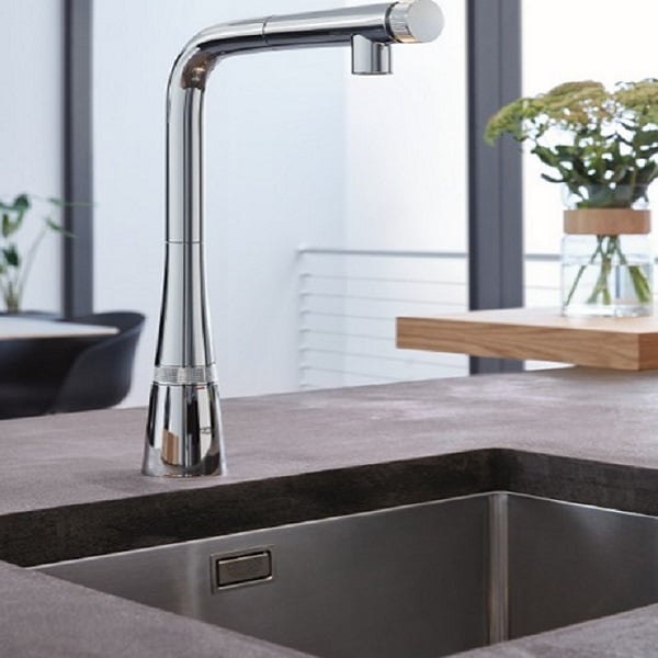 Robinet de cuisine au-dessus d'un évier en inox, avec un design moderne et une finition chromée.