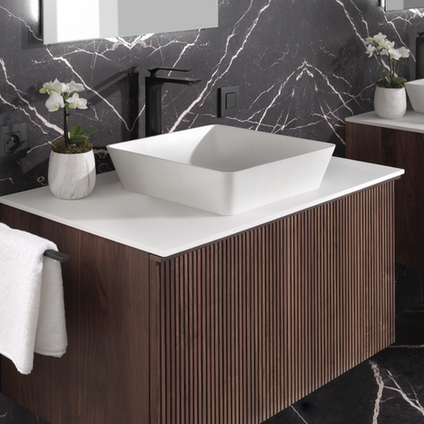 Un meuble de salle de bain avec un lavabo carré, des façades de tiroirs en bois et des robinets noirs modernes.