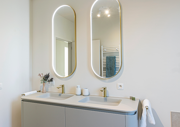 Ein stilvolles Badezimmer, in dem goldene Details für Wärme sorgen