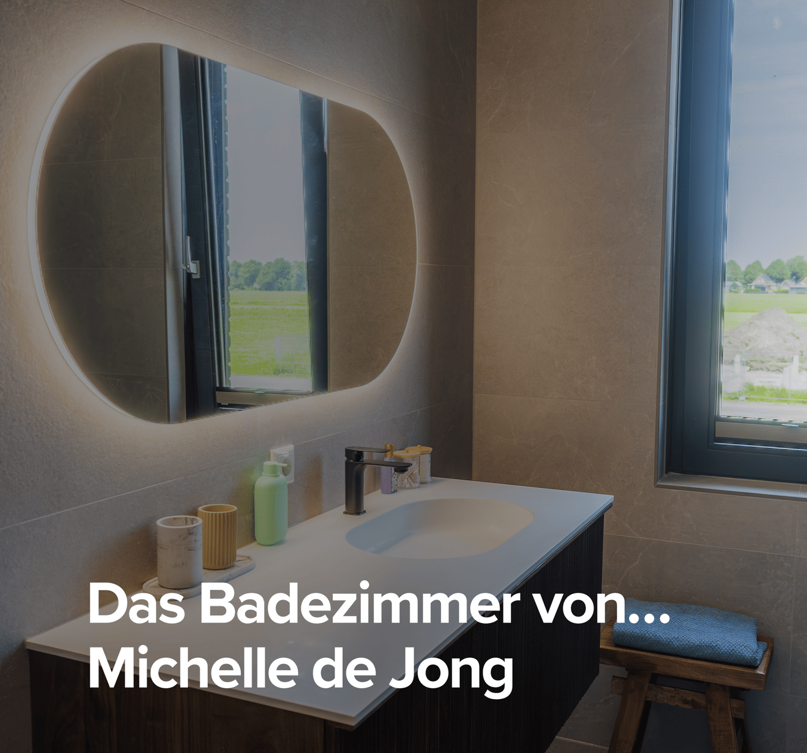 Überblick über das Badezimmer von Michelle de Jongg mit modernem Waschtisch, beleuchtetem Spiegel und Glasduschwand.