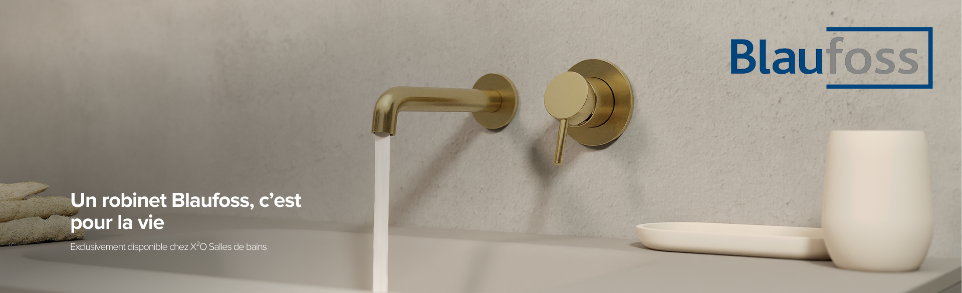 Robinet mural doré de Blaufoss au-dessus d’un lavabo avec mur en béton – disponible exclusivement chez X²O Salles de bains.