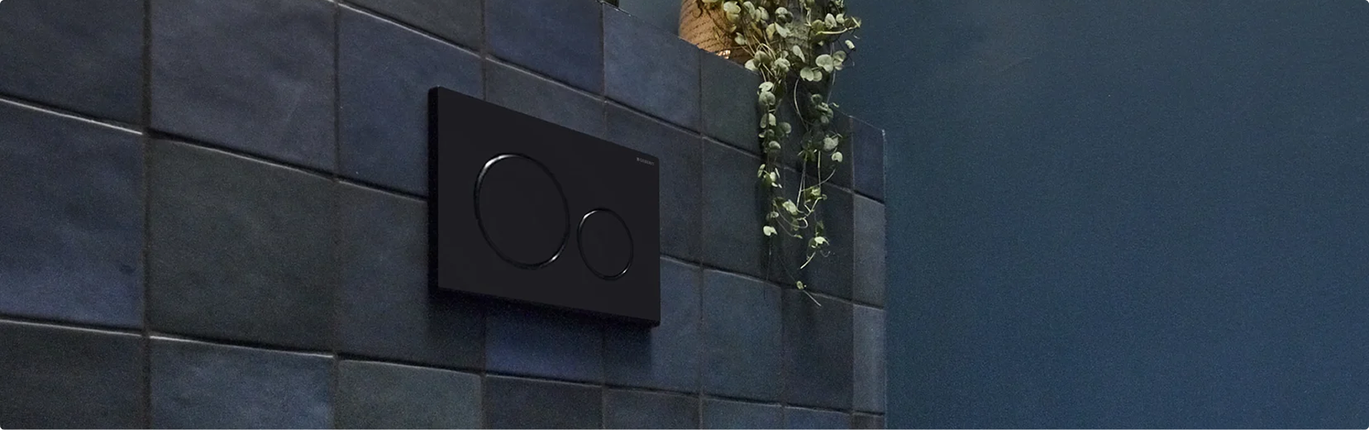 Schwarze Geberit Sigma20 Betätigungsplatte von x²o Badezimmer an einer dunklen Fliesenwand.