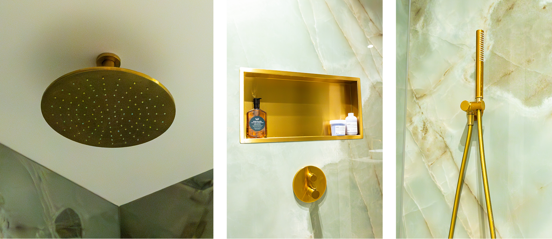 Op deze foto zie je een close-up van de luxe douche in de x²o badkamers ensuite. Bovenaan hangt een grote ronde regendouchekop in goud. Daarnaast is een gouden nis ingebouwd in de gemarmerde groene douchewand met verzorgingsproducten zoals een pompflacon en potjes. Ook is een gouden handdouche met flexibele slang tegen de marmerwand bevestigd.