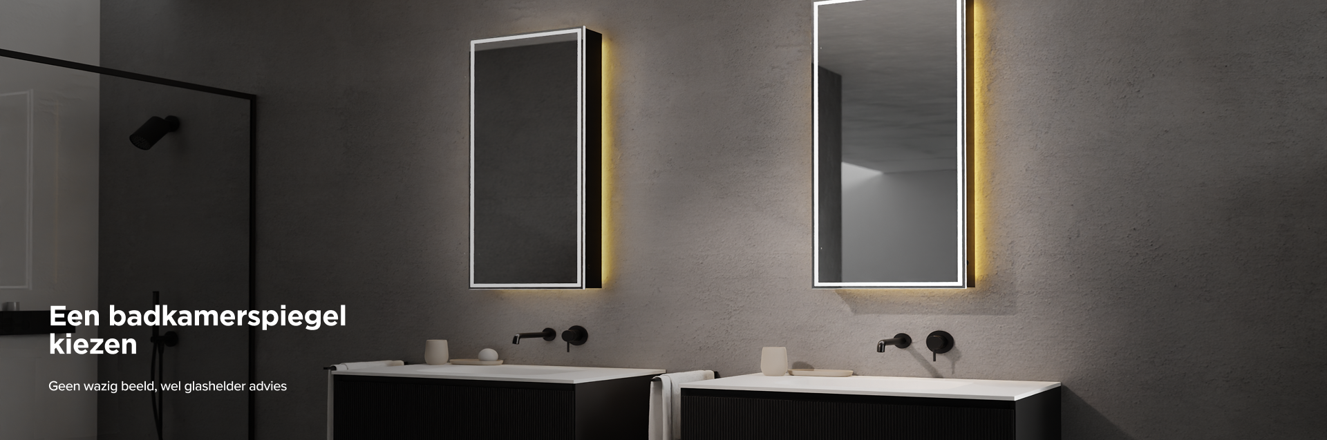 x²o badkamers met twee verlichte verticale spiegels aan een grijze wand, elk boven een strak zwart wastafelmeubel met witte waskom, minimalistische zwarte kraan, beige accessoires en een zwarte inloopdouche zichtbaar links.