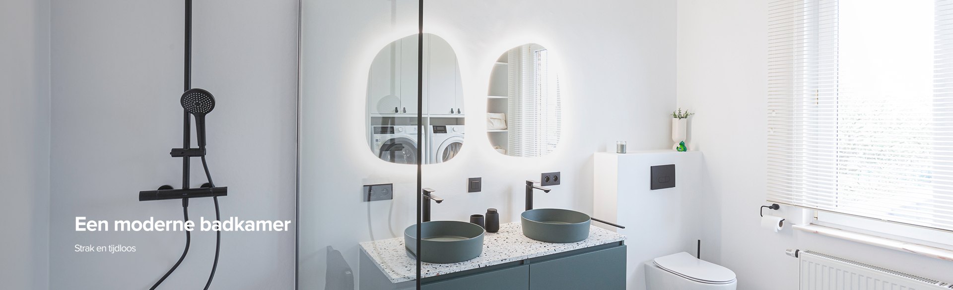 Moderne badkamer van x²o badkamers met zwarte regendouche achter een glazen douchewand, dubbele wastafel met groene opzetkommen, twee organisch gevormde spiegels met ledverlichting, een wandhangend toilet en grote ramen met witte jaloezieën die zorgen voor veel natuurlijk licht.