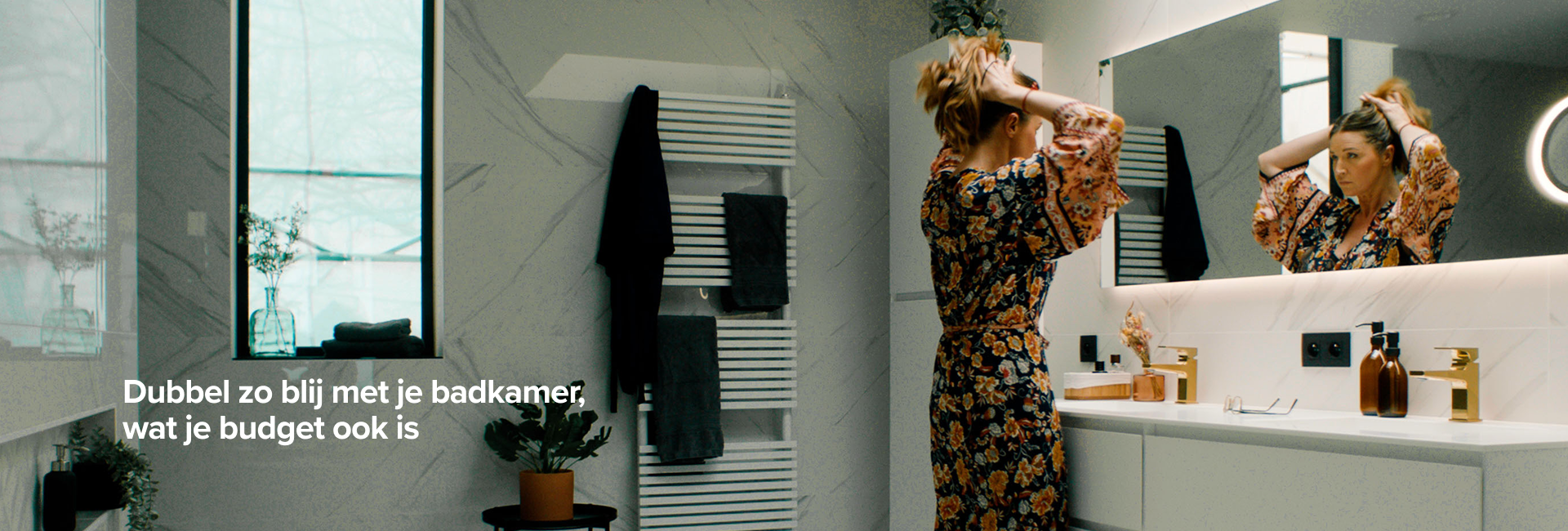 Vrouw maakt zich klaar voor de spiegel in een stijlvolle badkamer met witte marmeren muren, X2O badkamers.