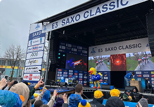 Publiek voor het podium van de E3 Saxo Classic met branding van X²O badkamers en ducky op het podium.