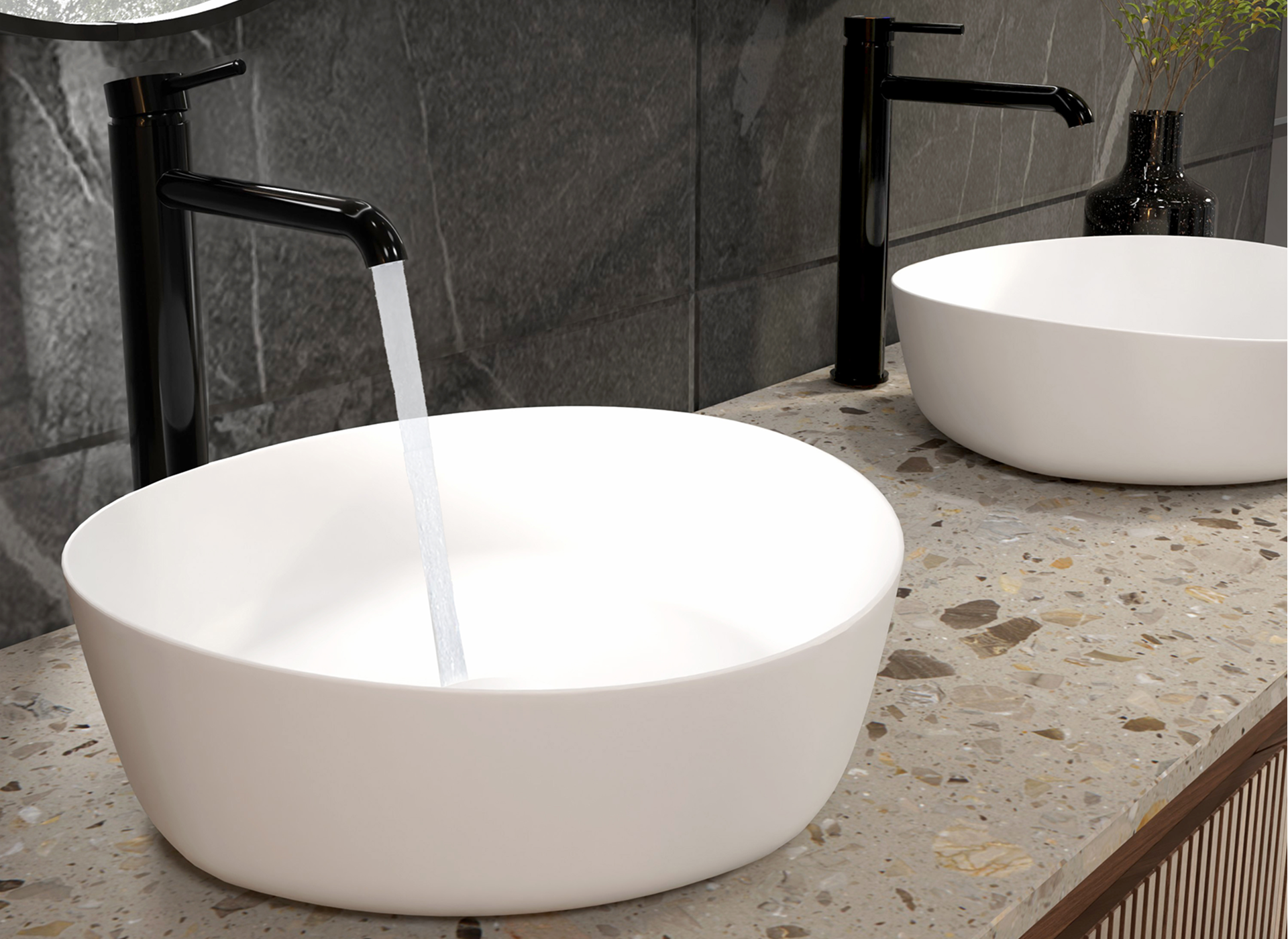 Ensemble de salle de bains moderne avec deux vasques blanches et des robinets Blaufoss hauts en noir brillant, placés sur un plan de travail en terrazzo. Disponible exclusivement chez X²O Salle de bains.