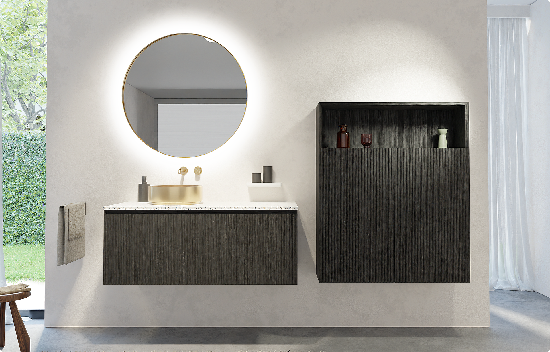 Storke Badezimmermöbel in dunklem geriffeltem Holz mit weißer Terrazzo-Waschtischplatte, runder Aufsatzwaschschale in Champagnergold mit passender Armatur, unter einem runden Spiegel mit integrierter Beleuchtung und neben einer offenen Wandnische mit dekorativen Accessoires in einem Badezimmer von x²o Badezimmer.