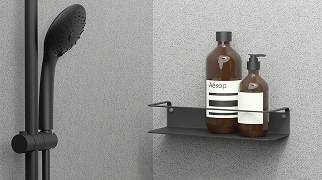 Zwart X²O doucheplankje met verzorgingsproducten tegen een grijze wand.