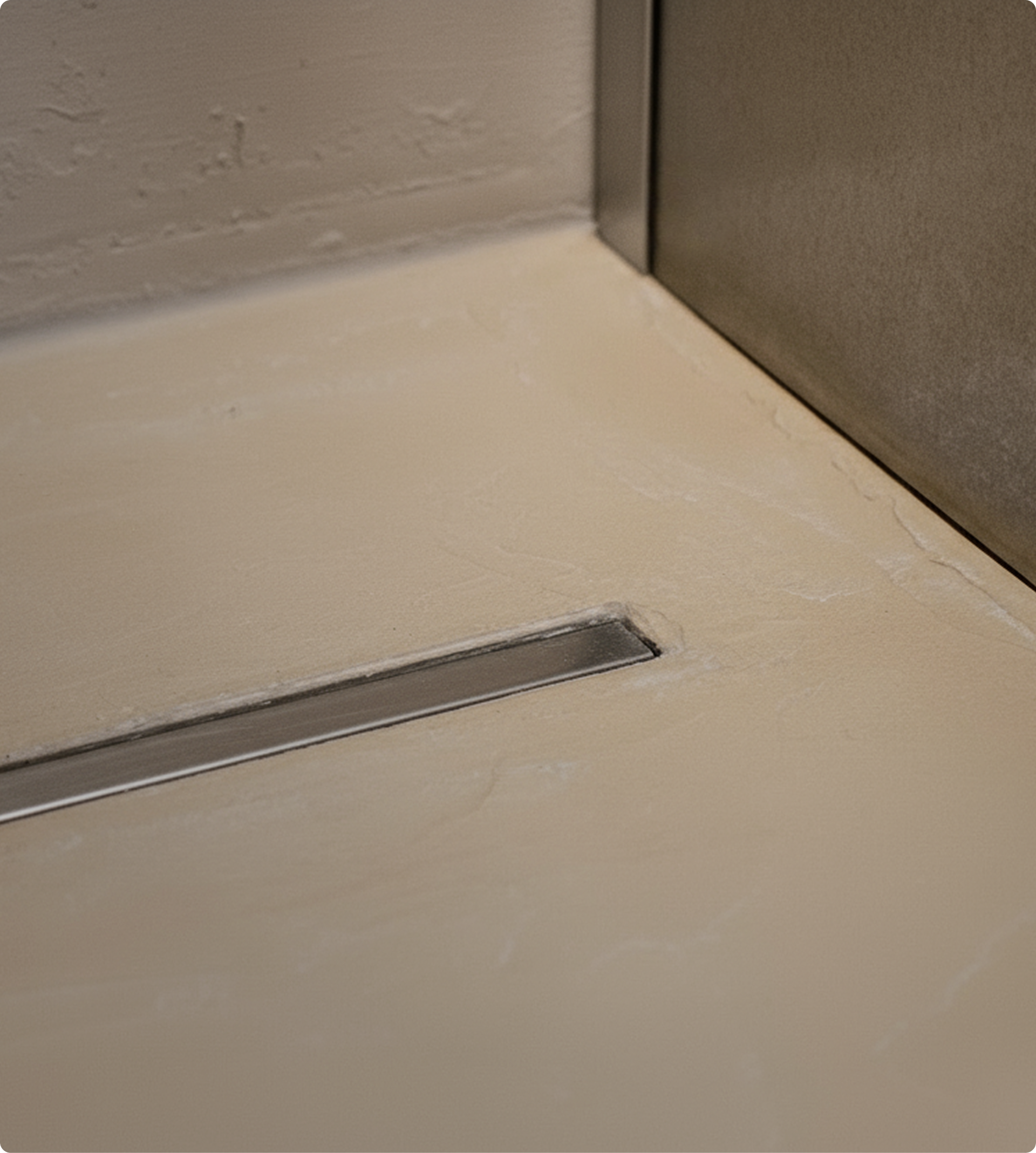 Detail van een afvoergoot in een douche met lichte kalkaanslag – X²O Badkamers