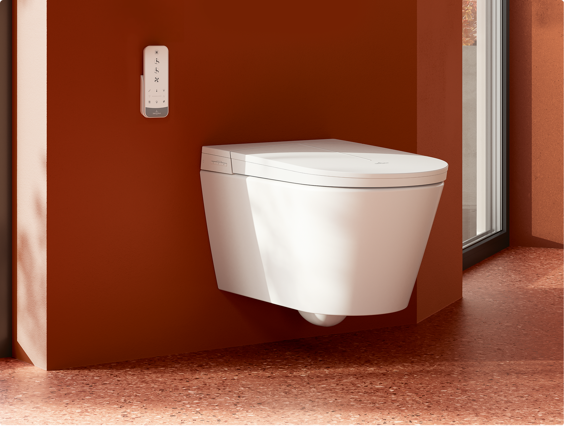 Wit hangend douche wc met gesloten zitting en wandbediening op een terracotta muur, in een badkamer van x²o badkamers.