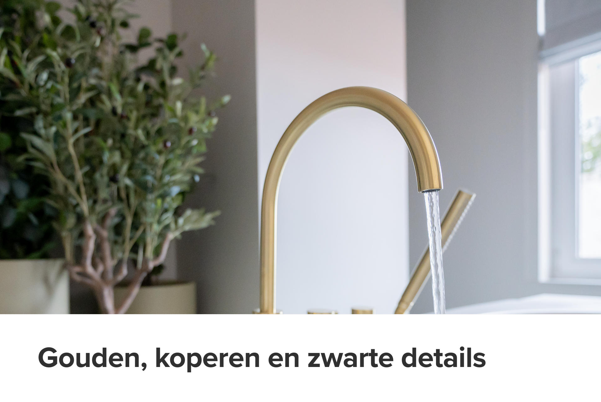 Detailopname van een goudkleurige kraan in een x²o badkamers setting. Stromend water komt uit de boogvormige kraan, op de achtergrond groene planten en zacht daglicht. De afwerking straalt verfijning en luxe uit.