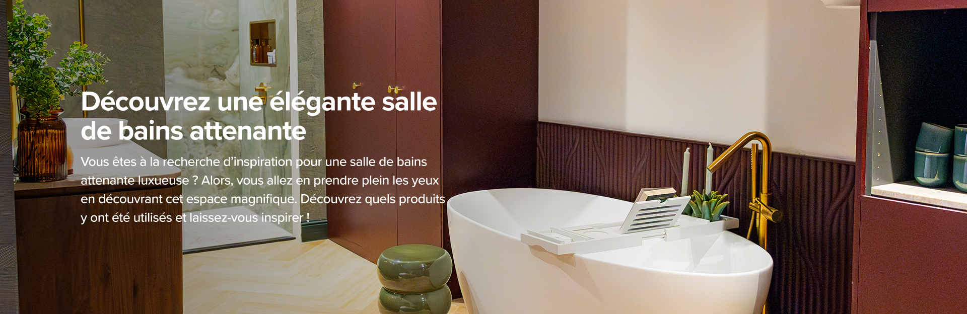 Sur la photo, on voit une salle de bains x²o badkamers ensuite luxueuse avec une baignoire blanche autoportante, un robinet doré et un meuble-lavabo élégant en bois avec un plan de travail en marbre. Un grand vase brun avec une plante verte, des bougies parfumées et des flacons de parfum décorent le meuble. La douche est équipée d'une douche de pluie dorée, d'une niche dorée contenant des produits de soin et d'une douchette fixée sur un mur en marbre vert. Il y a aussi des toilettes séparées avec un papier peint rose à motif jungle et des carreaux muraux rouges, complétant l’ambiance chic.