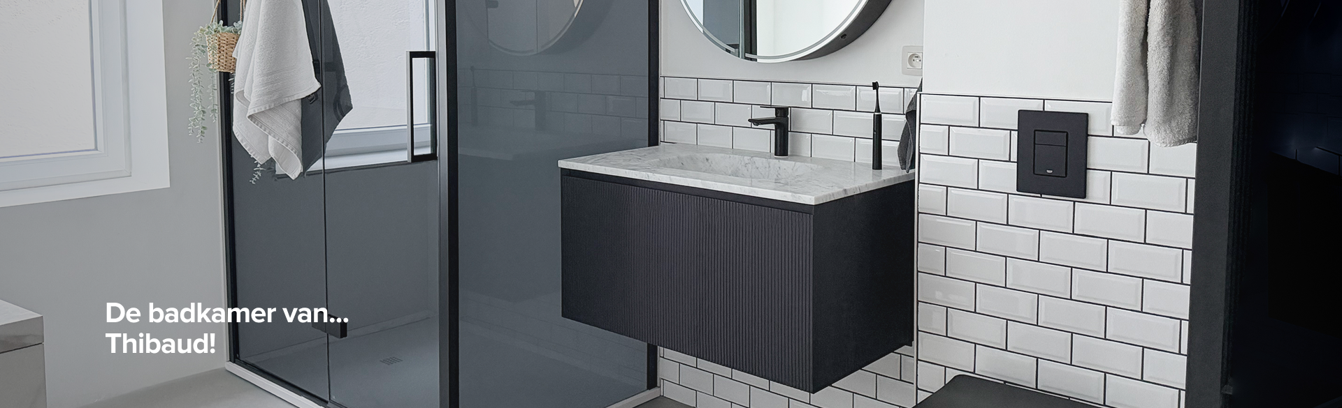 Badkamer van x²o badkamers met douche, zwart meubel, ronde spiegel en toilet, met tekstoverlay “De badkamer van Thibaud”.